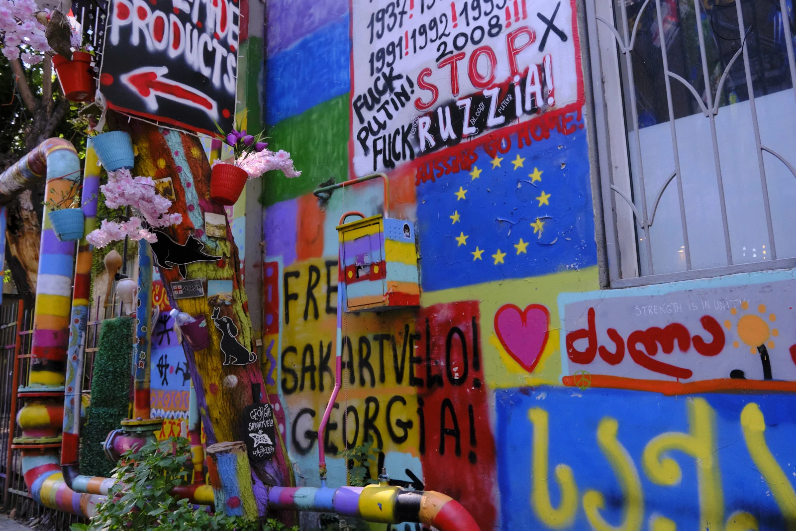 A brightly painted wall reading Sakartvelo and Georgia, with the European Union flag and political graffiti.