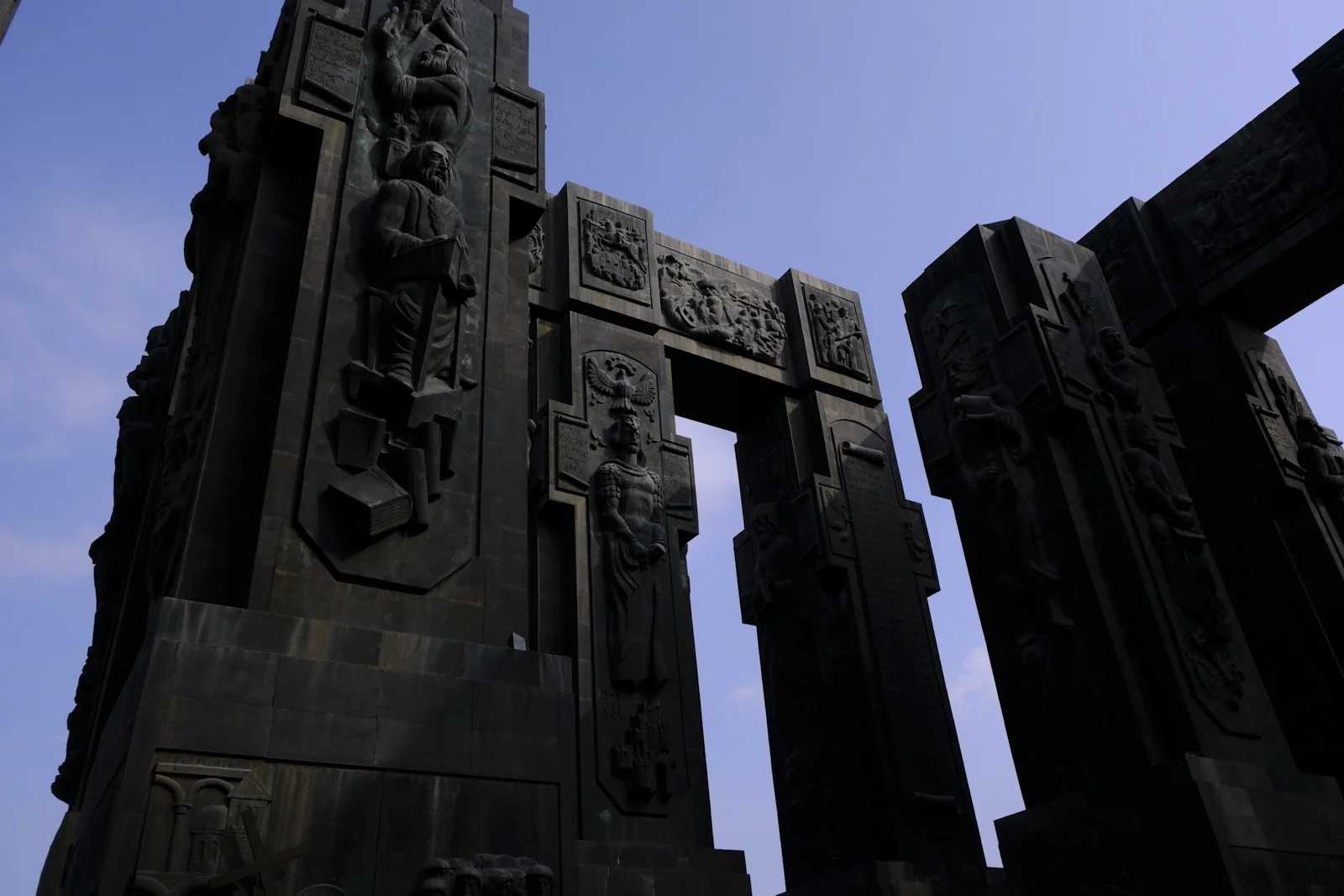 Silhouetted stone columns of the Chronicle of Georgia, carved with standing figures.