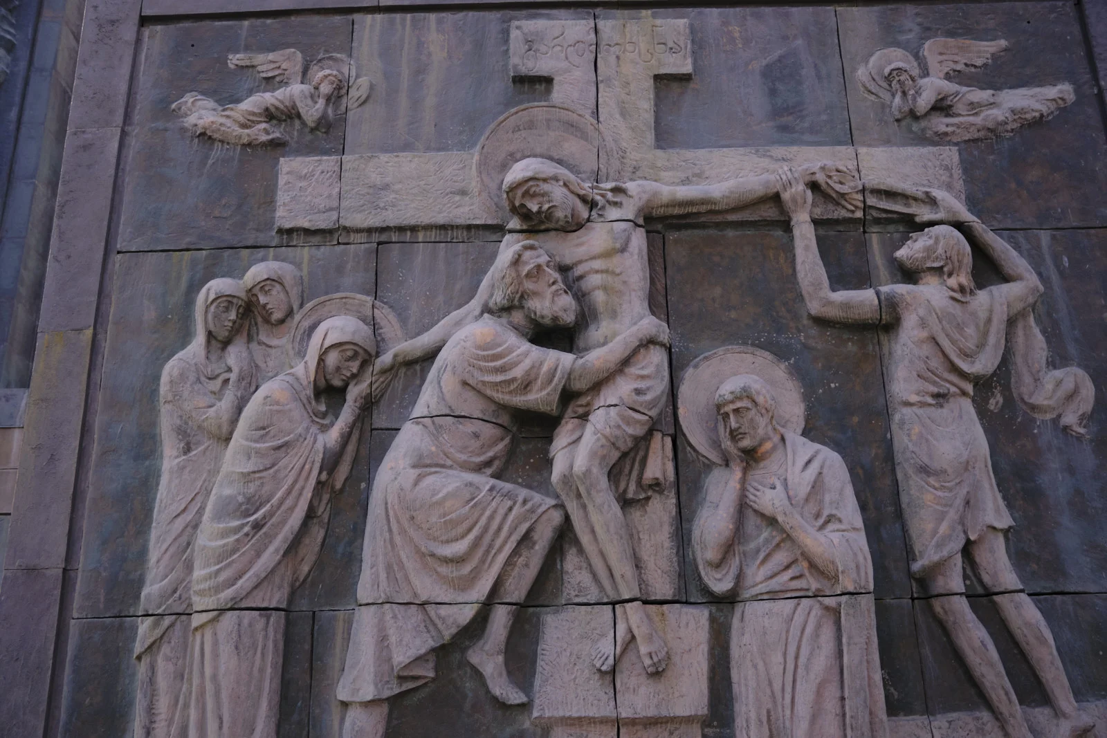 A stone relief of the descent from the cross, with mourners and angels, on the monument.