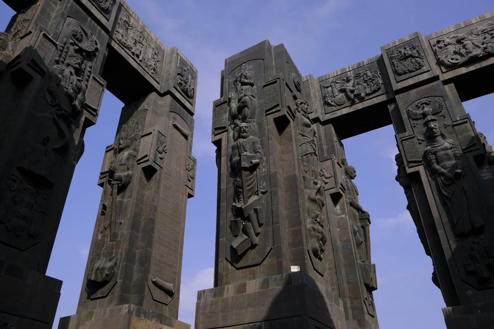Tall carved pillars of the Chronicle of Georgia seen from below, figures standing in the niches.