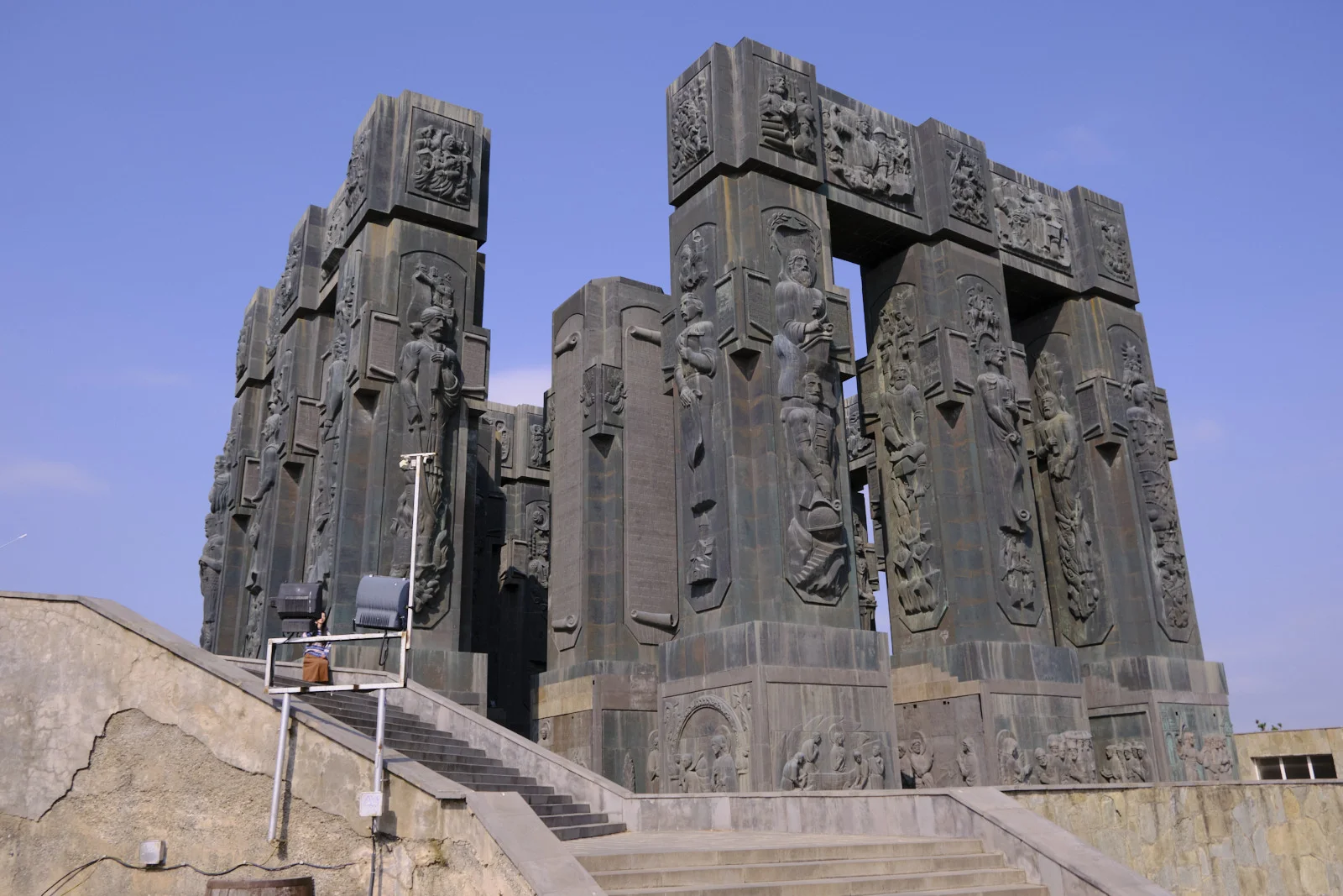 The Chronicle of Georgia from the side, with stairs leading up to the carved columns.