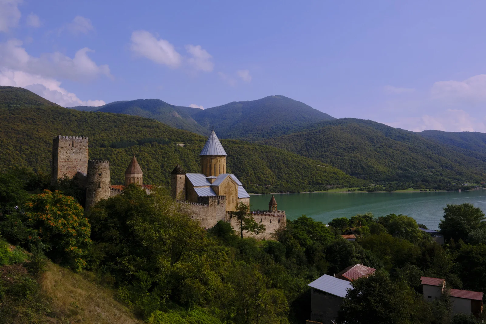 A wider view of Ananuri, towers and church, with the reservoir stretching into the hills.