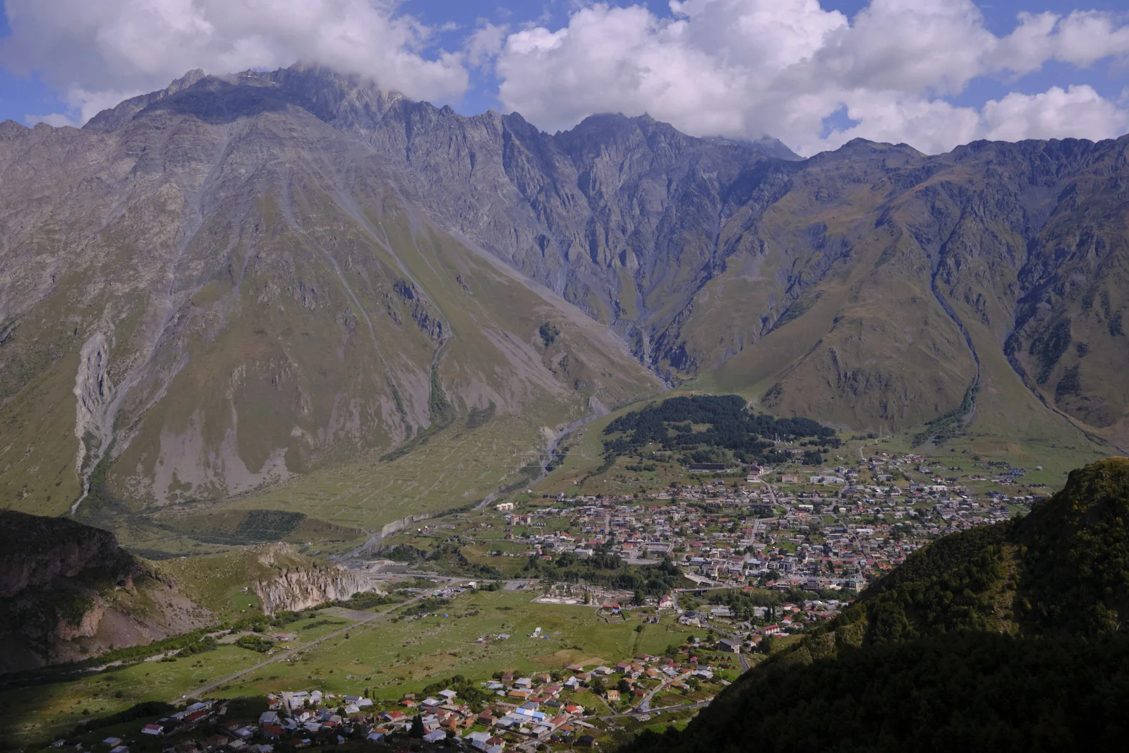 Stepantsminda spread in the valley, high peaks rising behind it.