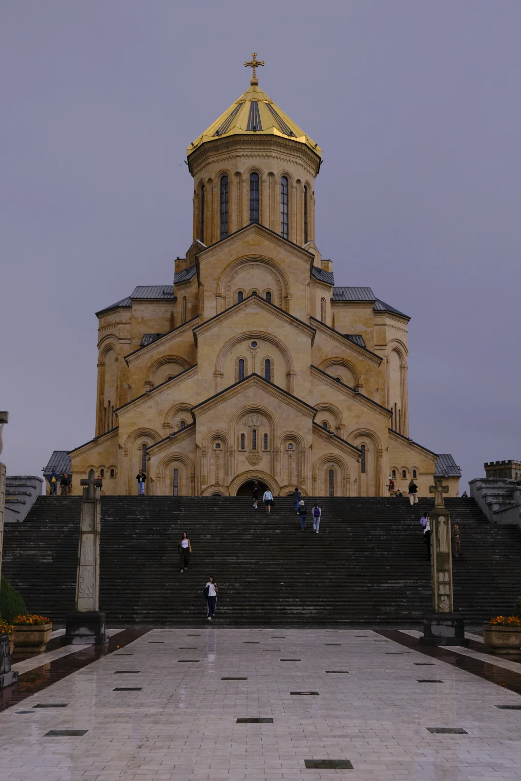 The golden dome of Sameba above a wide flight of wet steps.
