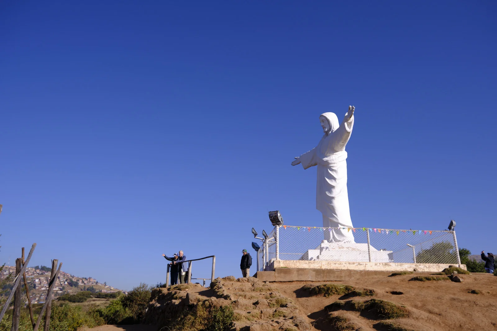 Cristo Blanco on the hillside above Cusco, the white statue on a fenced platform with the city’s rooftops below