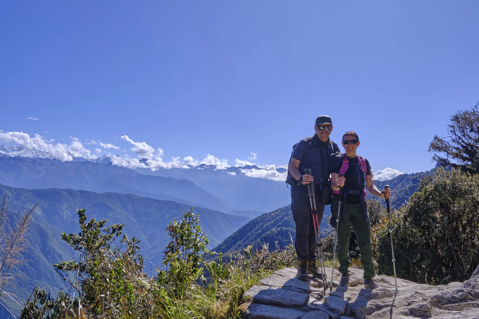 Original Inca stone paving through cloud forest on the approach to Phuyupatamarca, with distant snow peaks