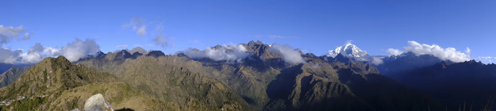 Phuyupatamarca: camp and ruins on the left ridge, cloud-wreathed peaks, and Salkantay’s snow dome at right
