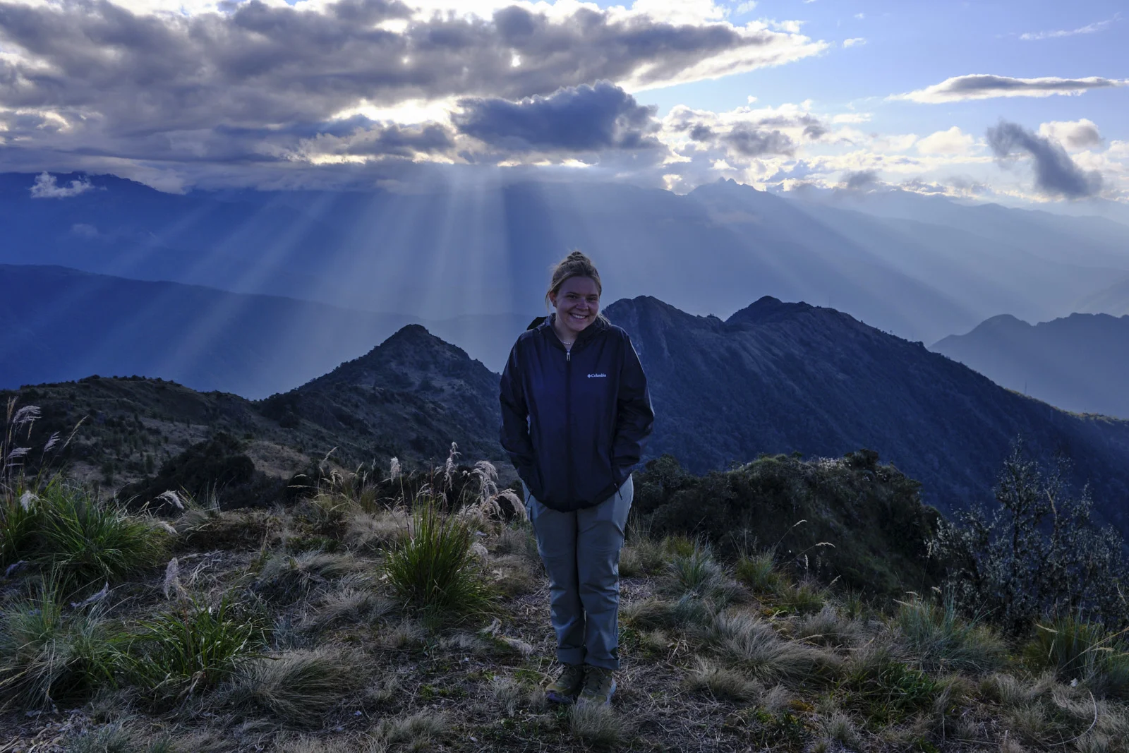Phuyupatamarca camp viewpoint at sunset, sunbeams over the ridges dropping toward the Urubamba drainages