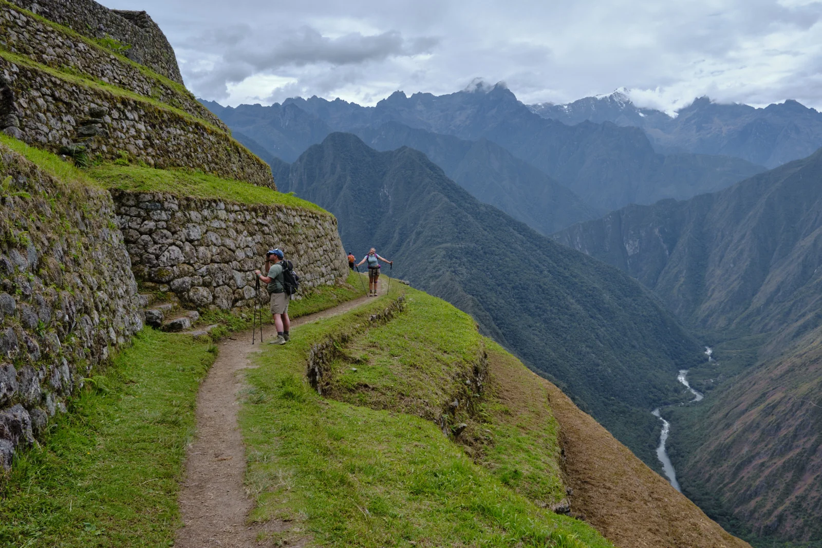 Terrace-edge trail at Intipata, fieldstone retaining walls and the Urubamba far below