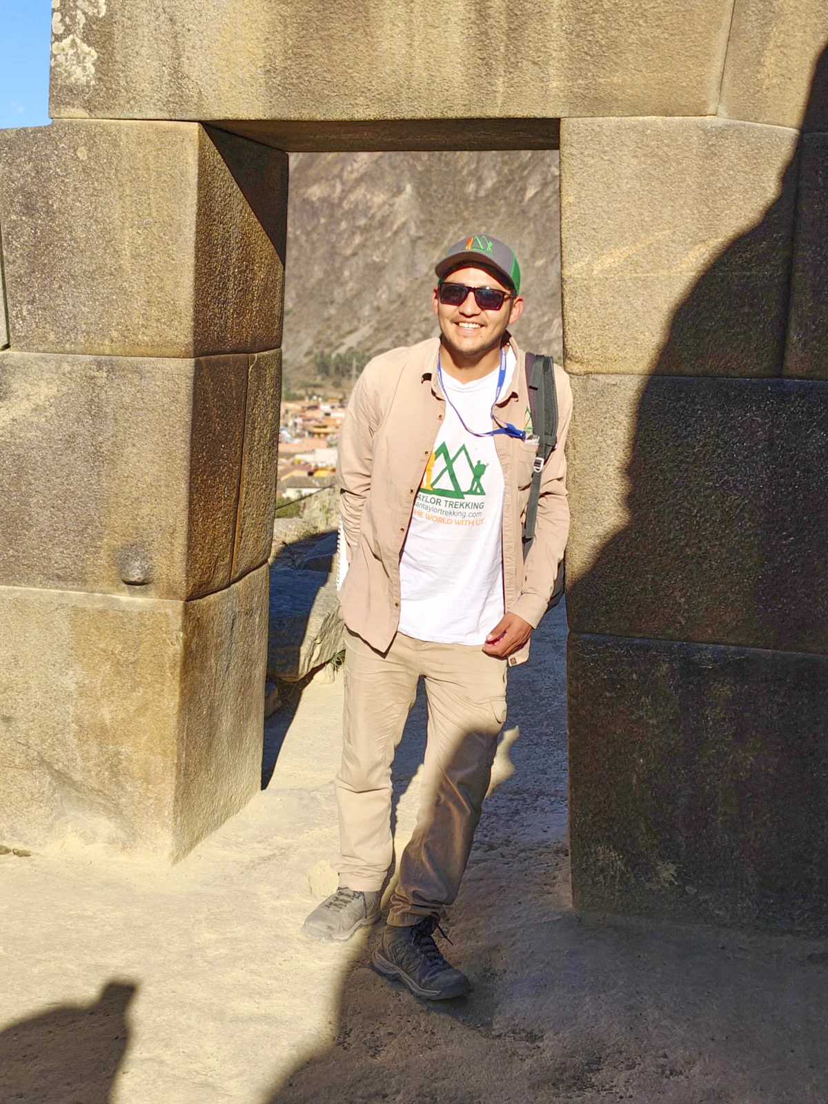 Trapezoidal Inca doorway of fitted stone at Ollantaytambo fortress, opening toward the town and Pinkuylluna hillside