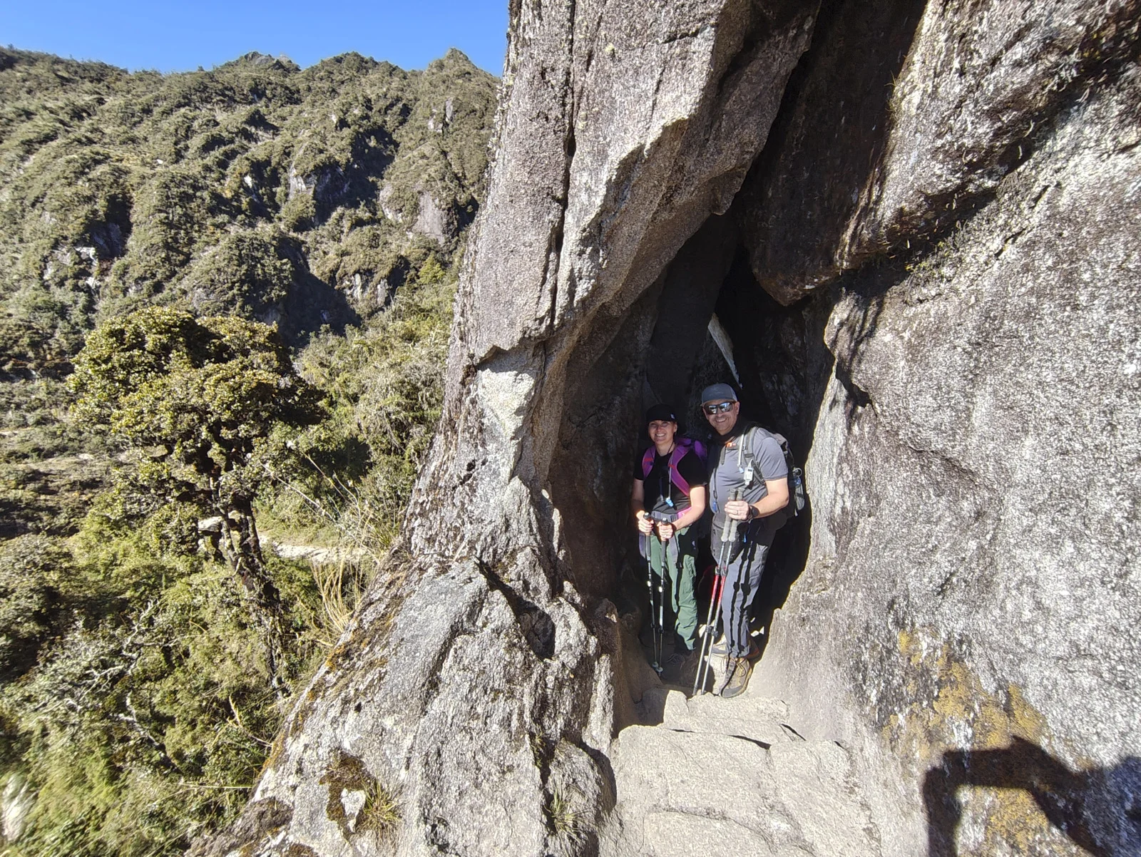 Rock-cut Inca tunnel and stairs at Phuyupatamarca, a narrow granite passage above cloud-forest slopes