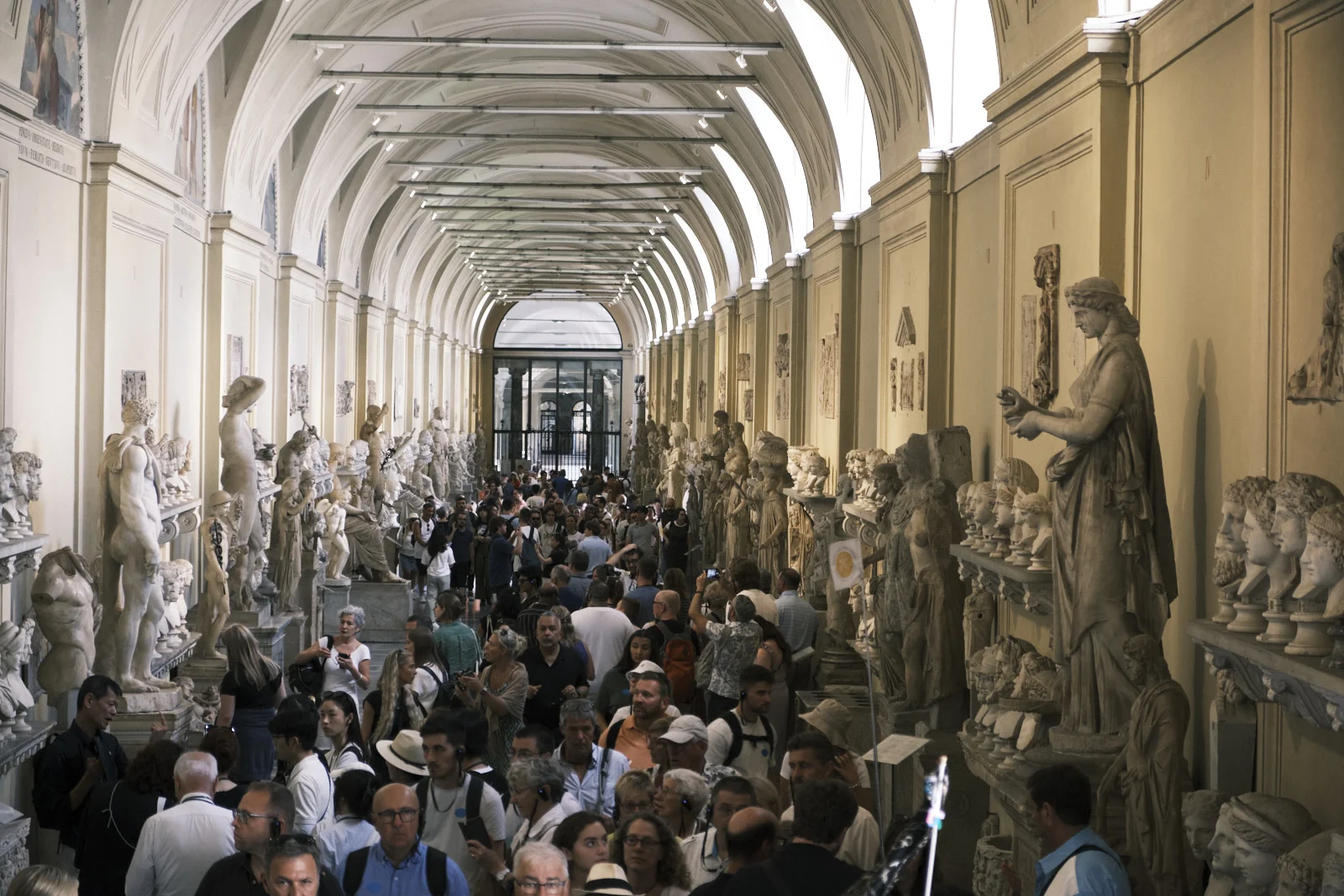 Crowded vaulted gallery of Roman sculpture in the Vatican Museums