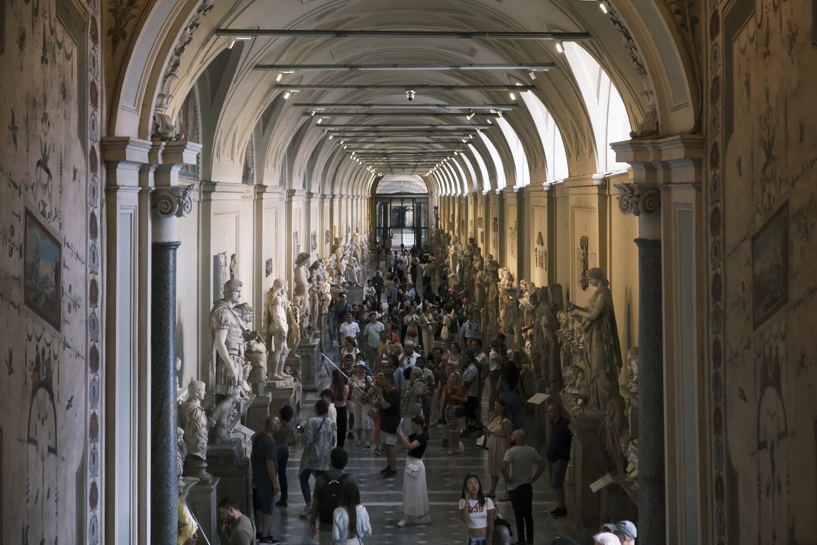 Long crowded sculpture gallery in the Vatican Museums