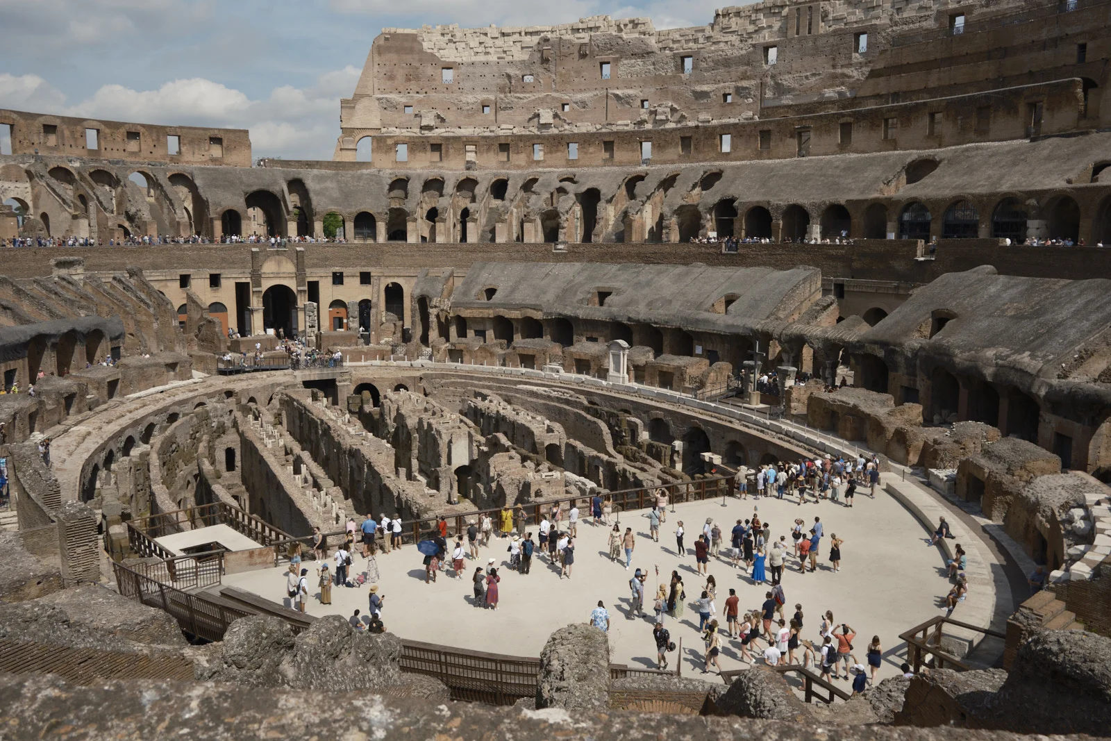Interior of the Colosseum with hypogeum and visitors on the arena floor