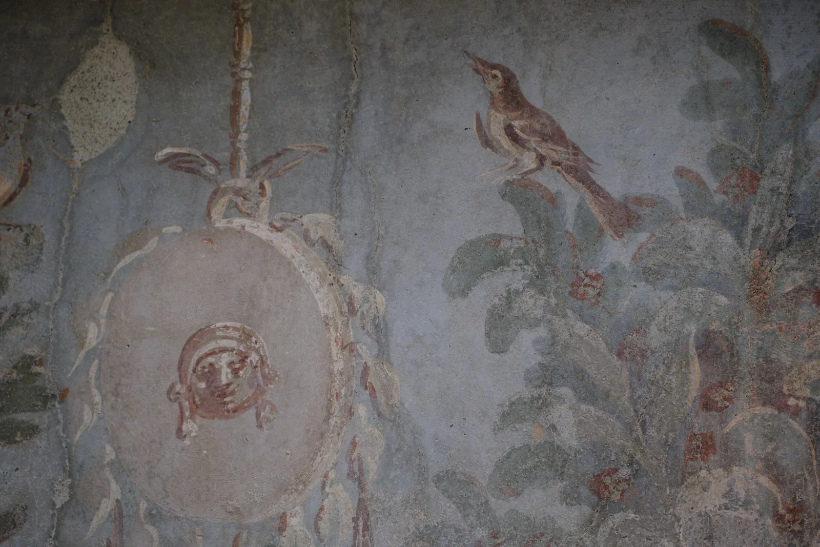 Roman fresco of a bird and a mask on a painted garland
