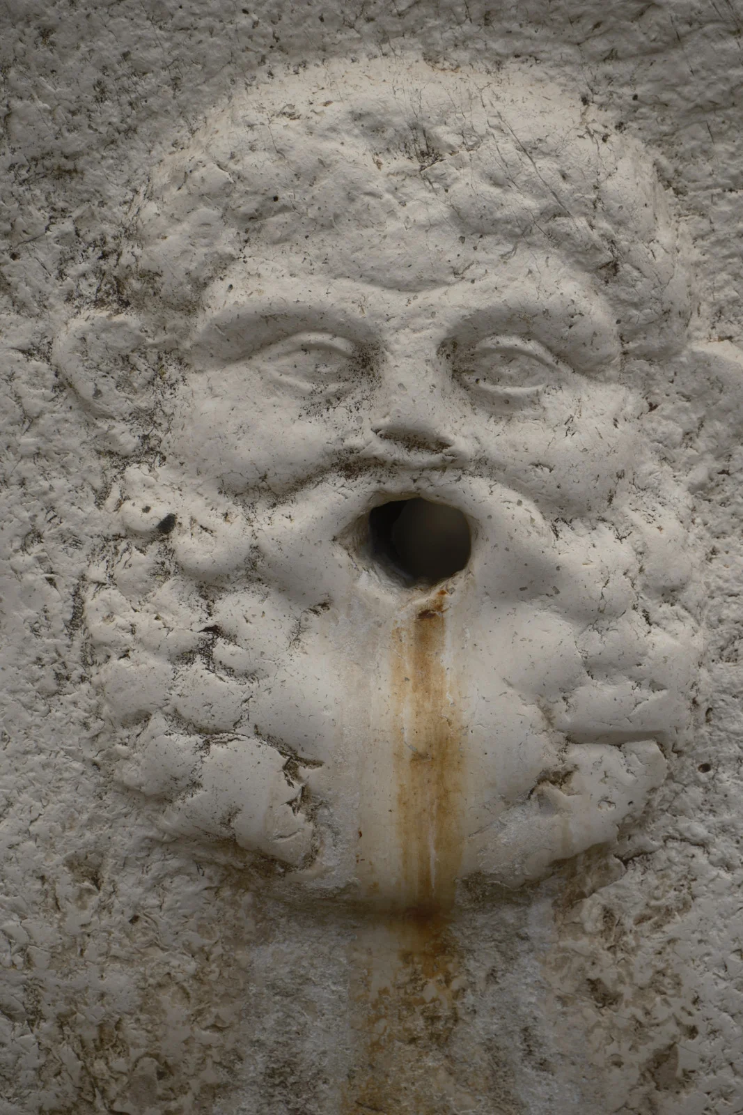 Worn stone face used as a fountain spout at Herculaneum