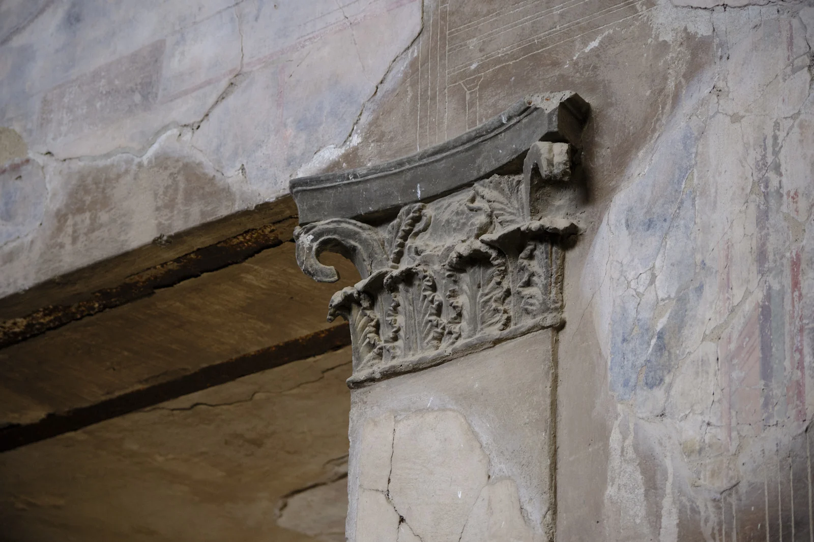 Corinthian capital against a plastered wall at Herculaneum