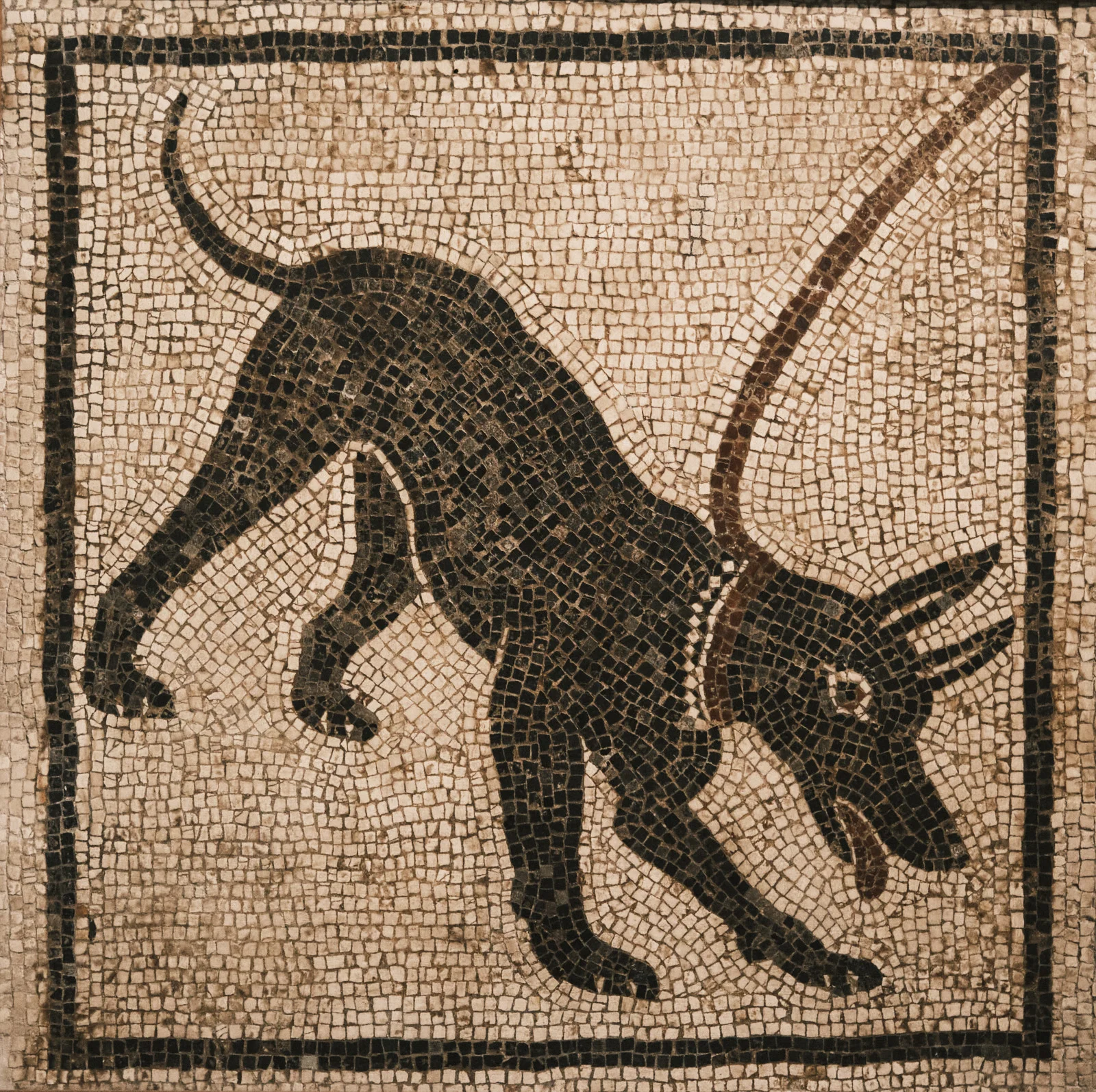 Black-and-white mosaic of a chained dog