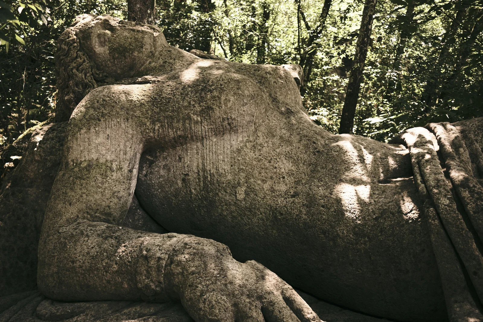 Colossal reclining stone figure in a forest at Bomarzo