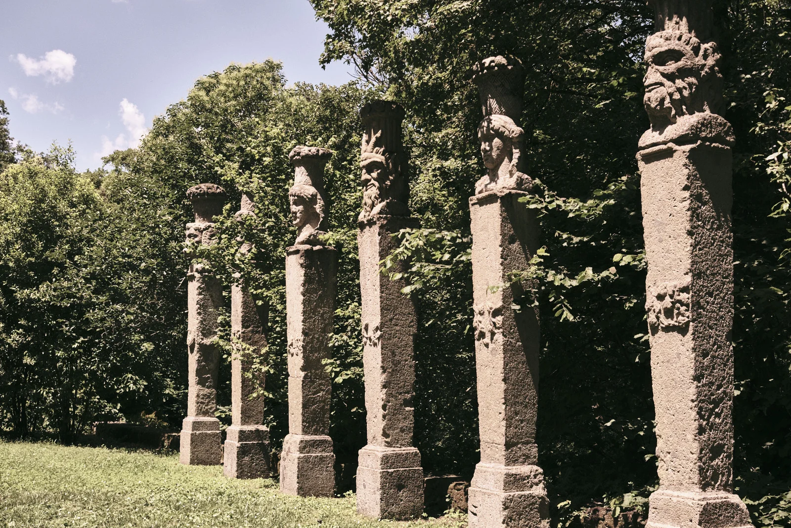 Row of carved stone herm pillars in a garden at Bomarzo