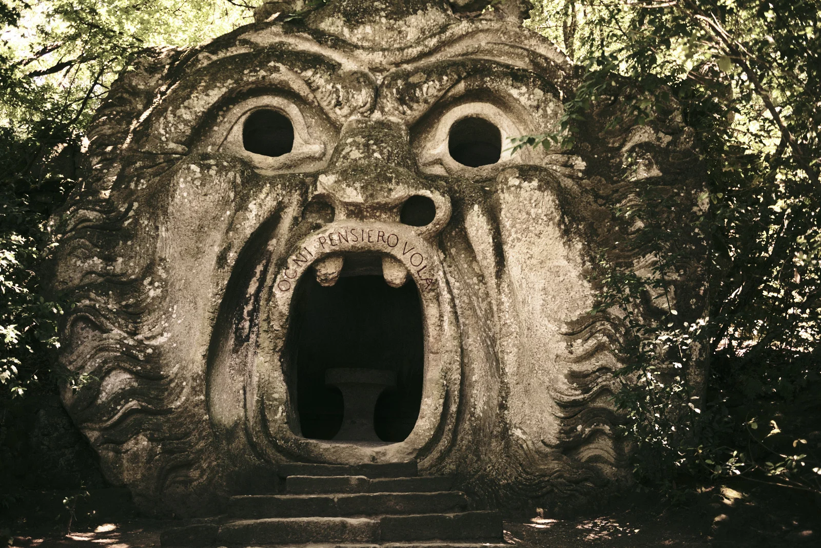 Giant carved face with an open mouth inscribed OGNI PENSIERO VOLA