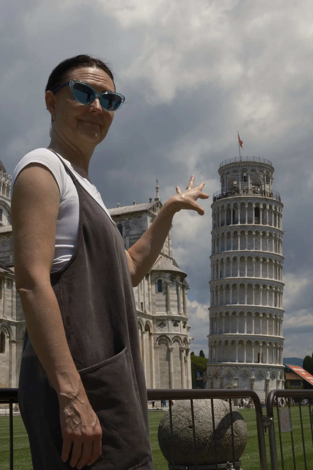 Woman posing as if holding up the Leaning Tower of Pisa