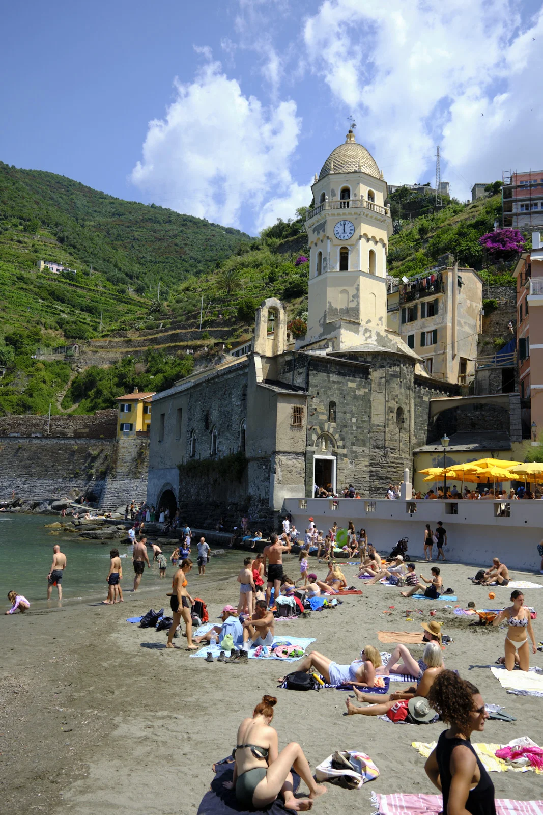 Beach and church with a gold-tiled campanile in Vernazza
