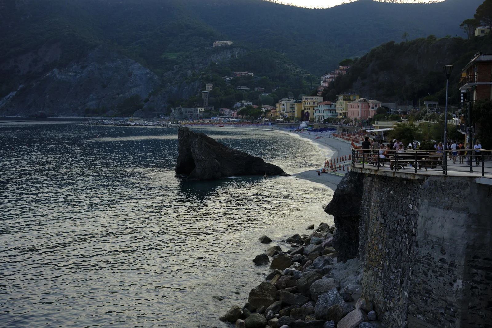 Monterosso beach and a pierced rock in the bay at dusk