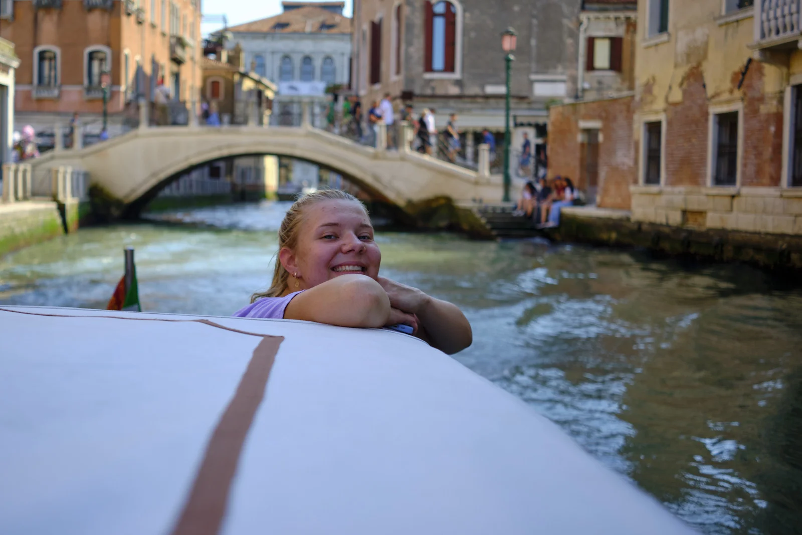 Person leaning on a boat rail in a Venice canal