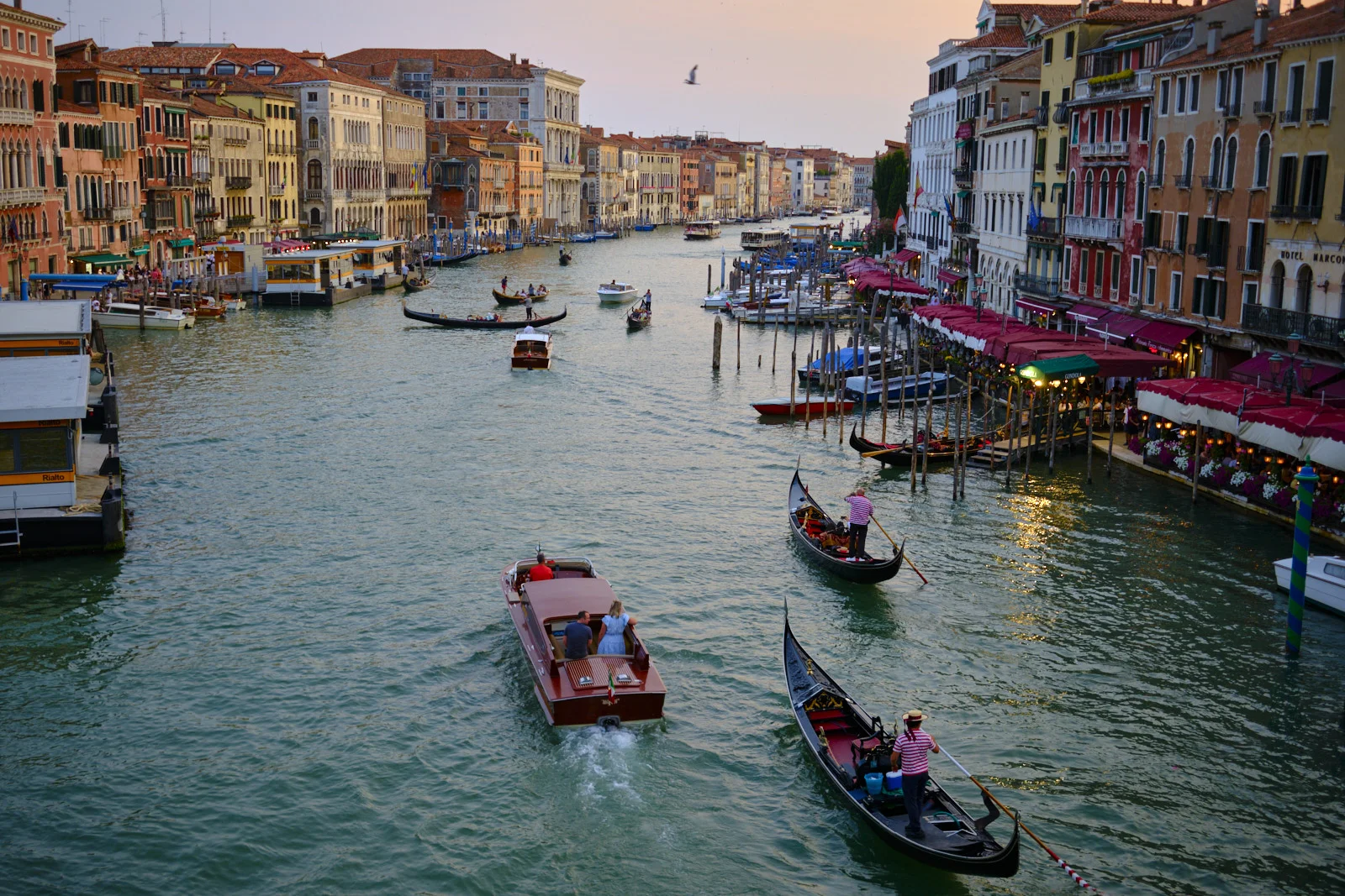 Grand Canal traffic of gondolas and a motorboat at dusk