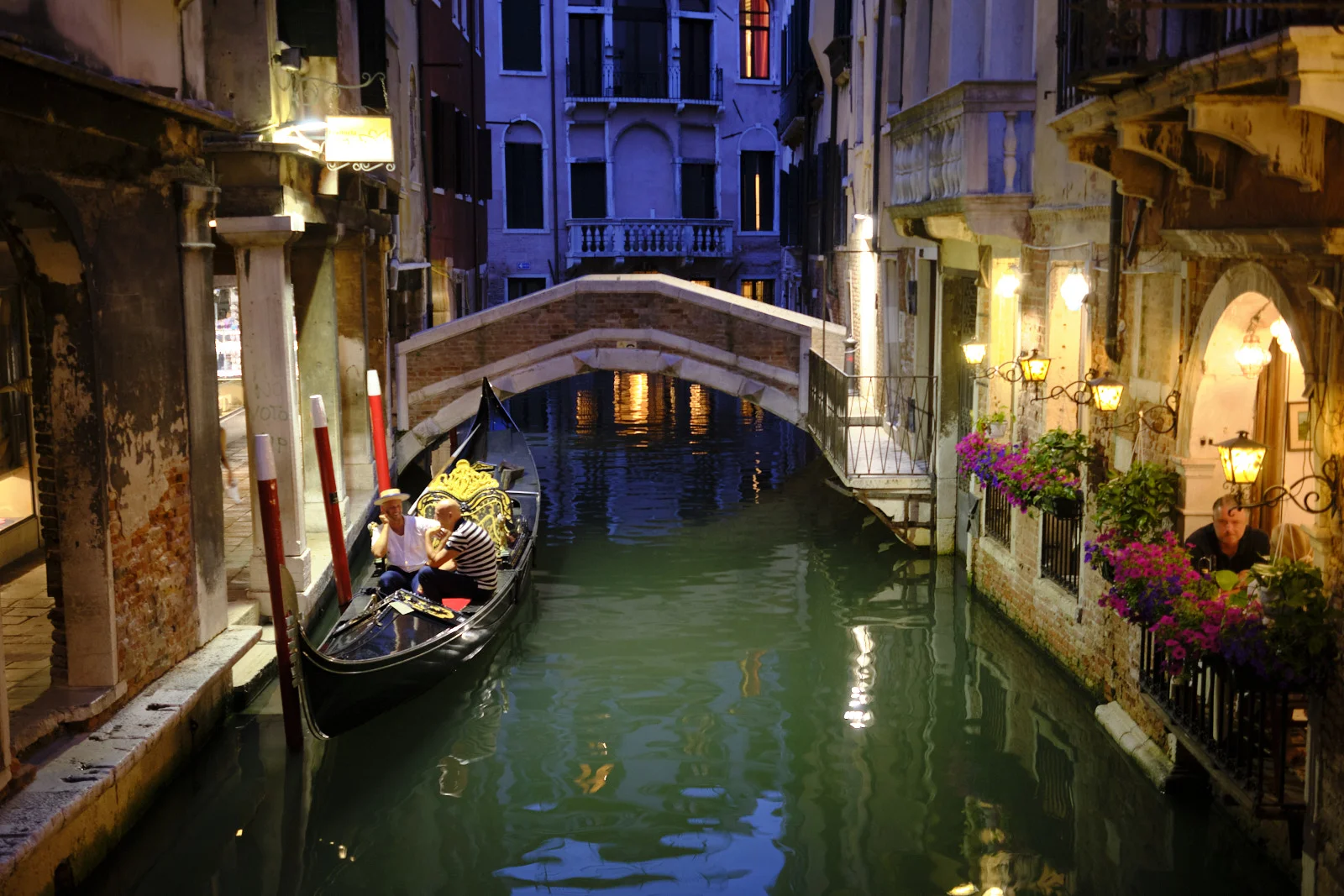 Gondola on a narrow canal at night in Venice