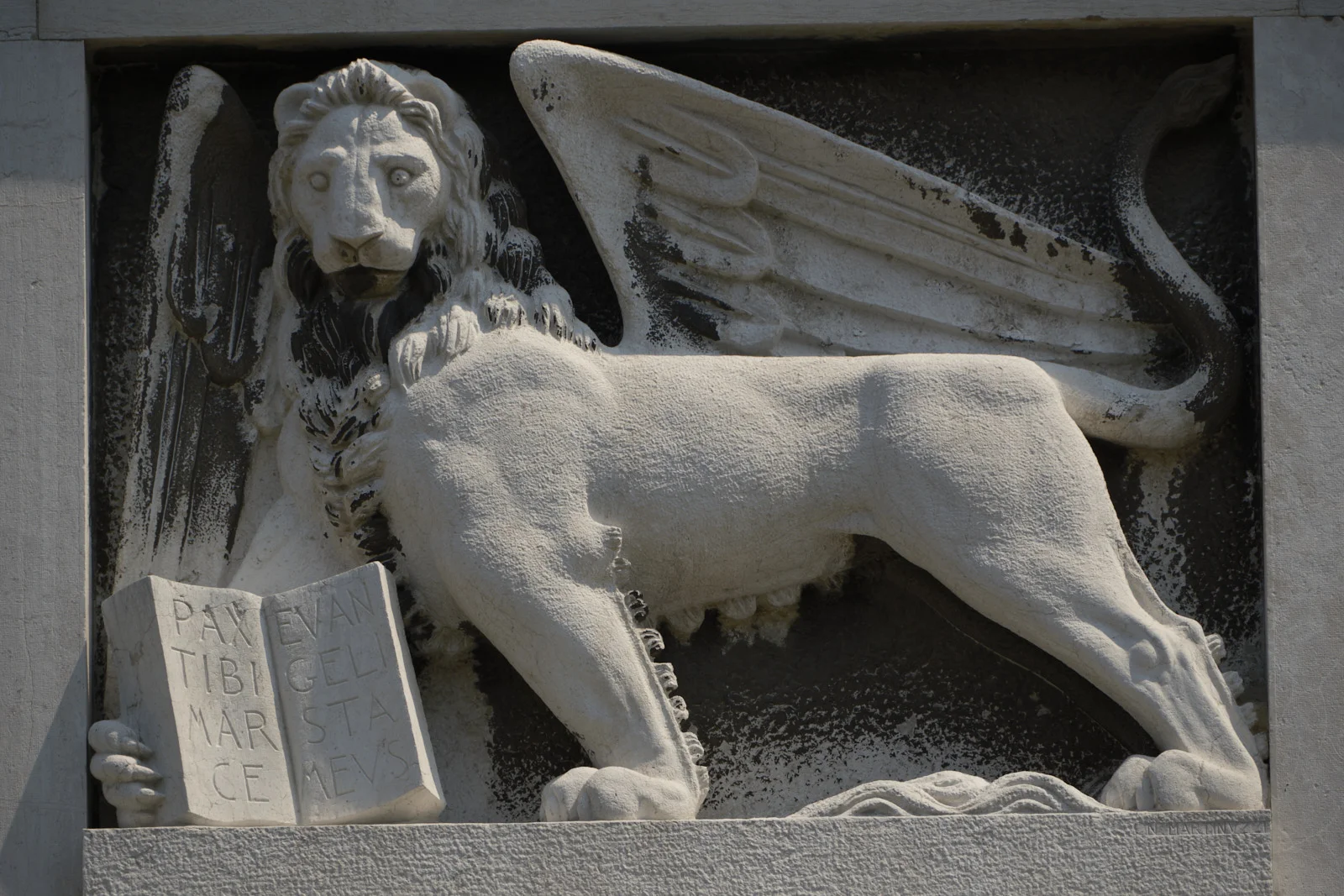 Stone relief of the winged lion of St. Mark holding a book