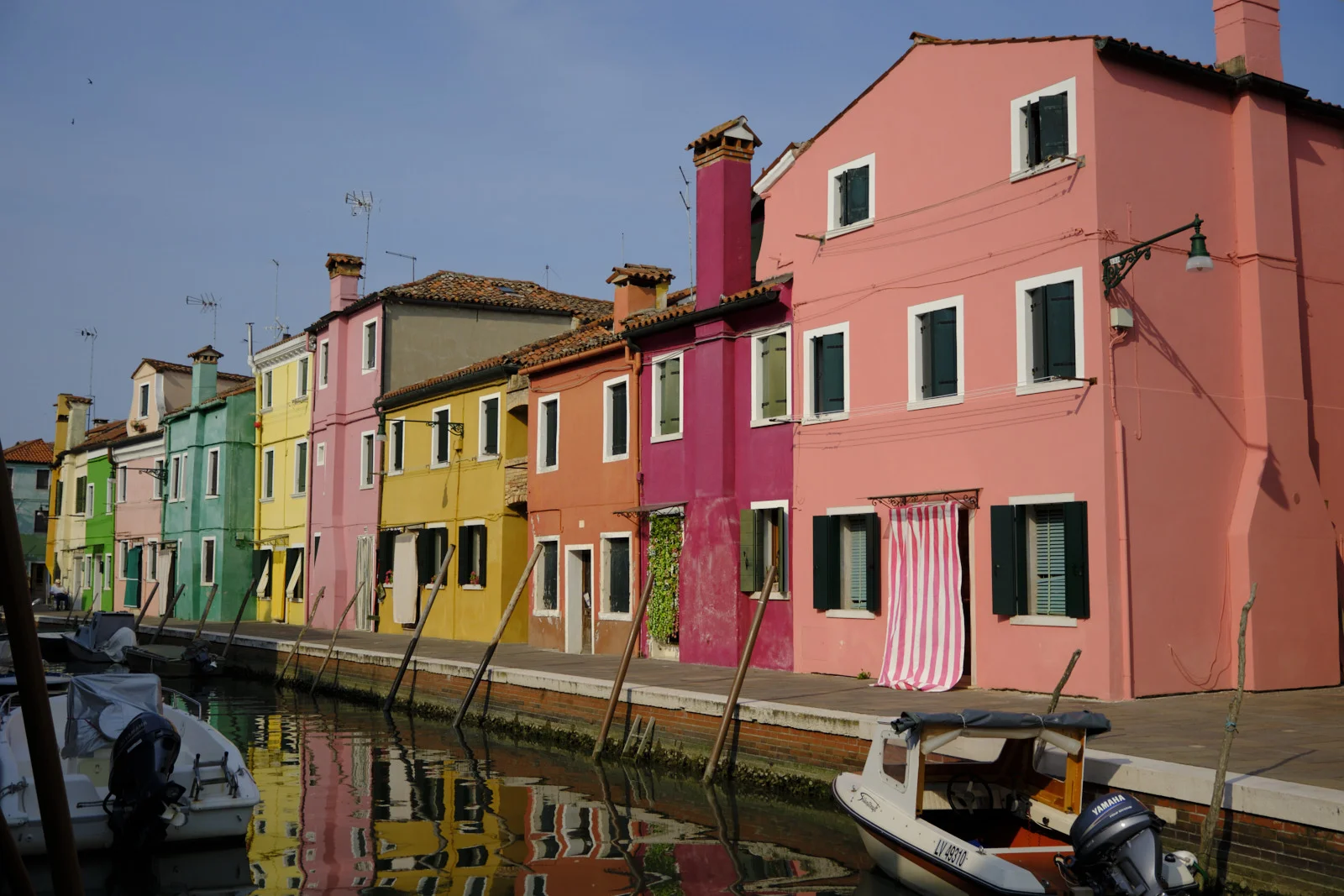 Long row of brightly painted houses on a Burano canal