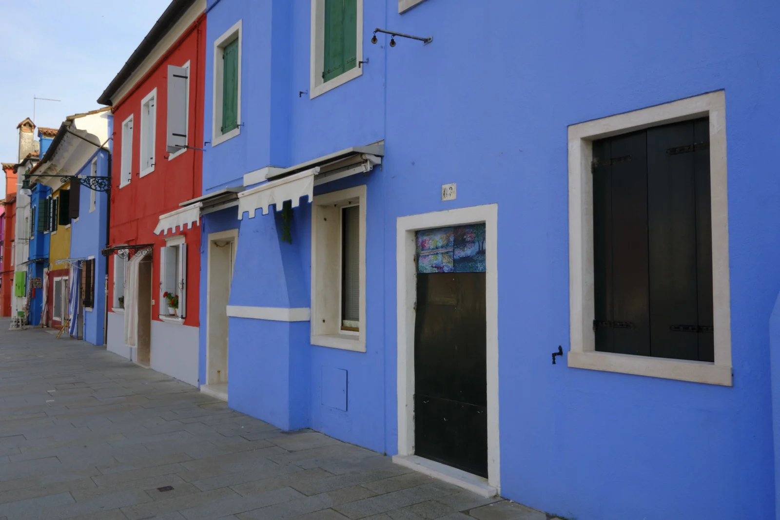 Bright blue Burano house next to a red one