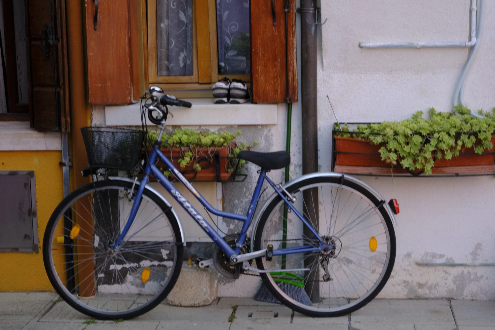 Blue bicycle against a house with wooden shutters in Burano