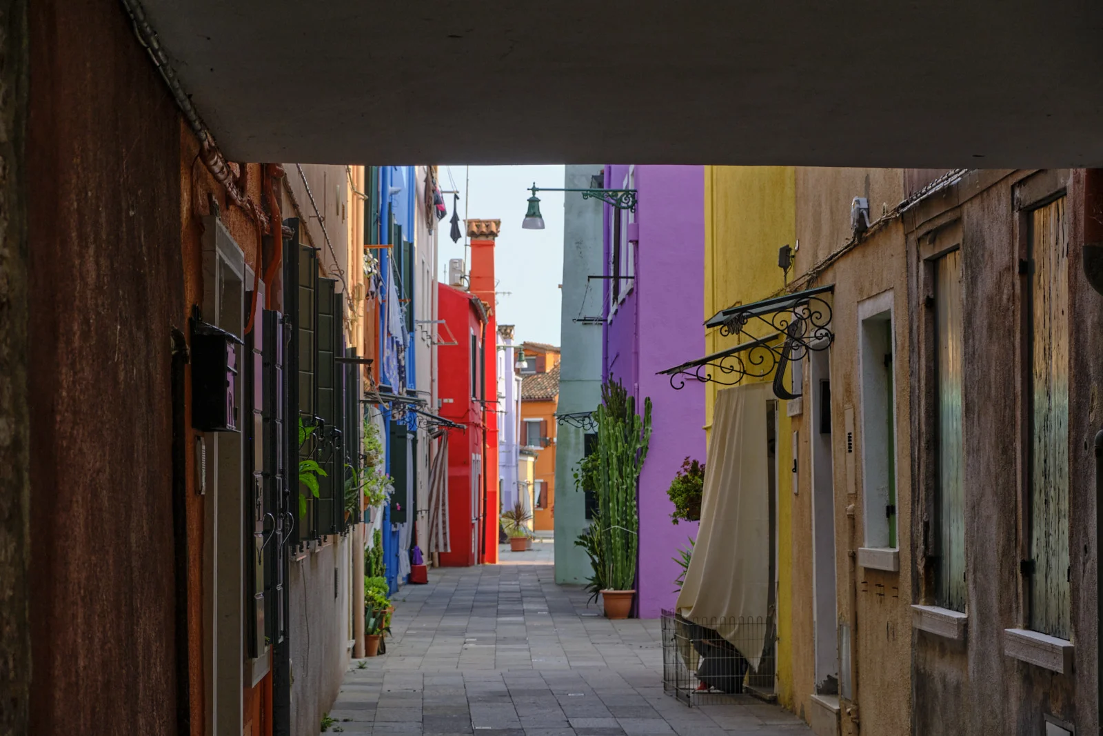 Covered alley looking toward colorful Burano houses