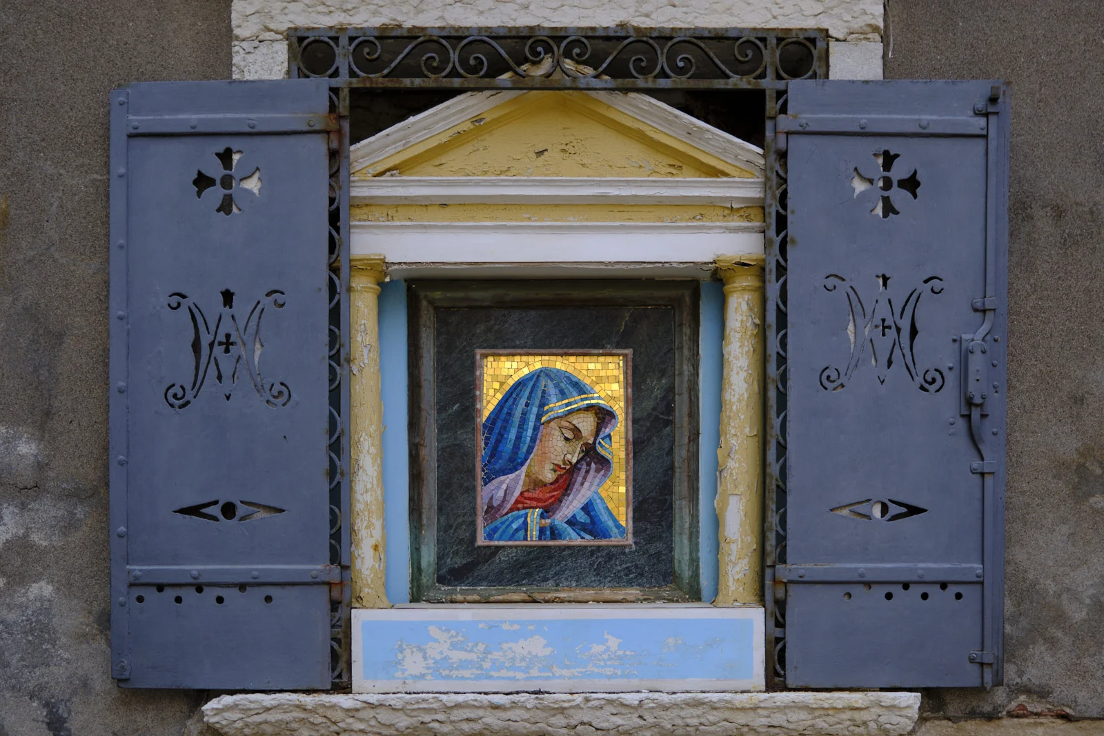 Small mosaic of the Madonna in a shuttered street shrine