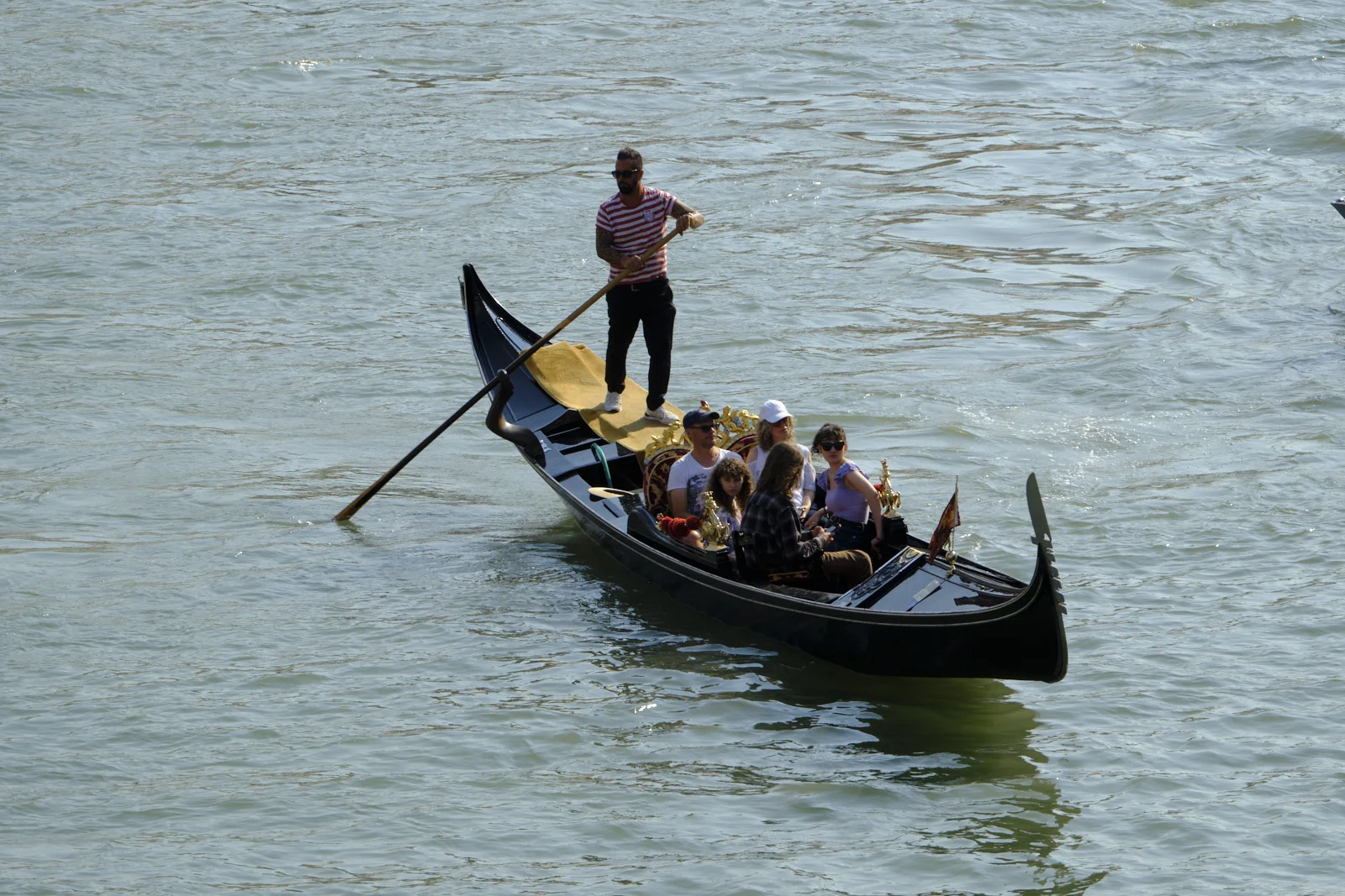 Gondola with a family and gondolier on a Venetian canal