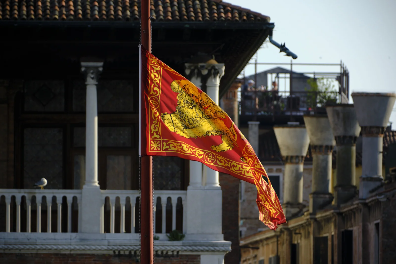Venetian flag with the winged lion flying before a palazzo