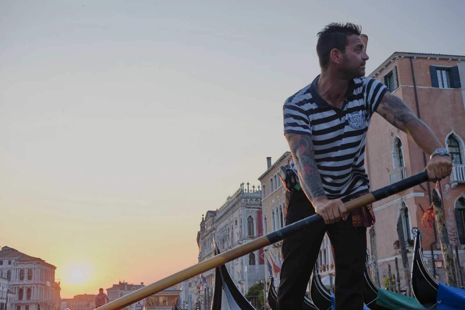 Gondolier rowing at sunset on the Grand Canal
