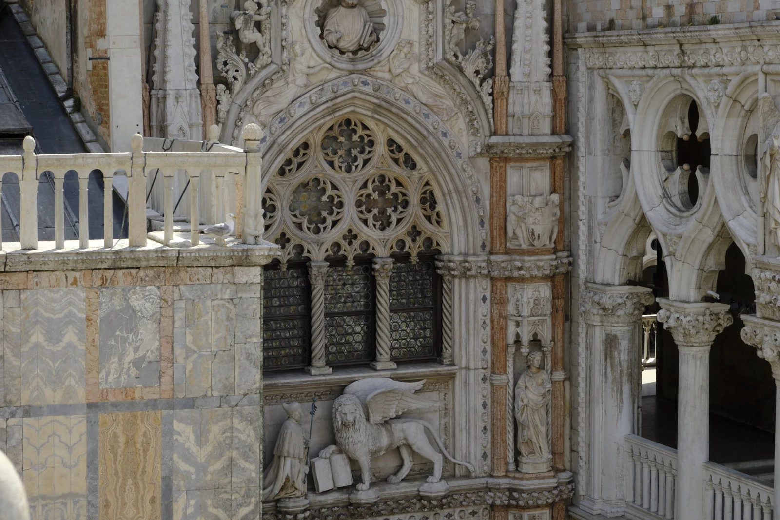 Gothic window and winged lion with kneeling Doge on the Porta della Carta