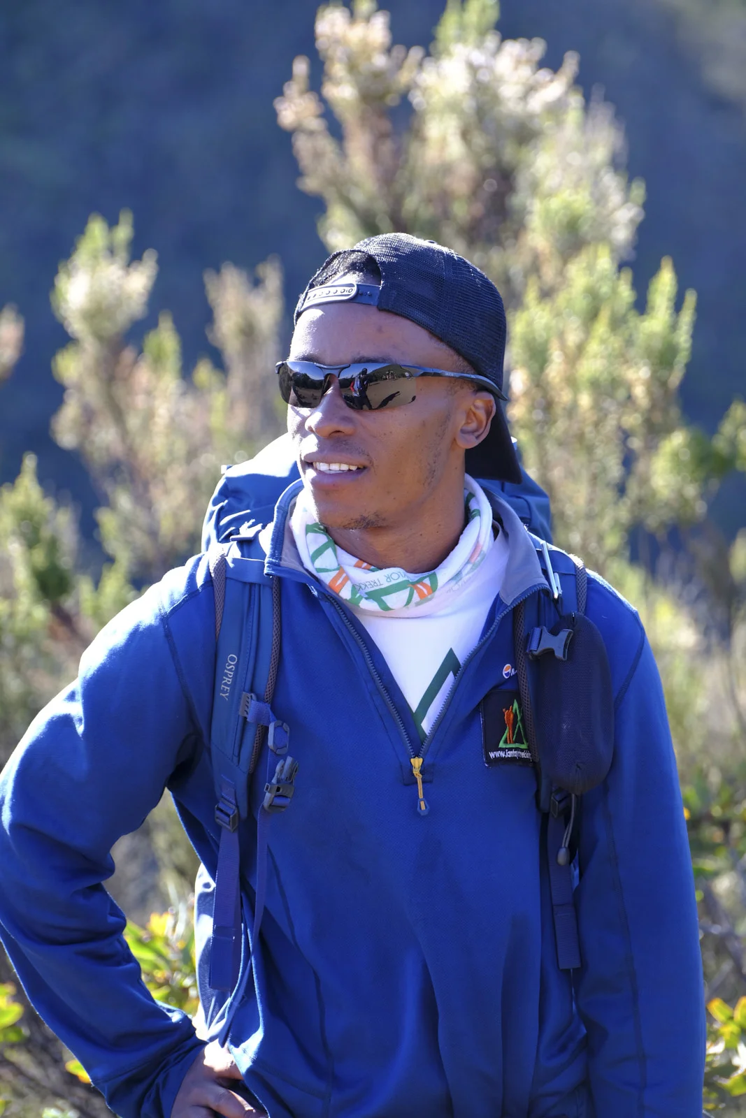 Mountain guide in a blue jacket and Osprey pack