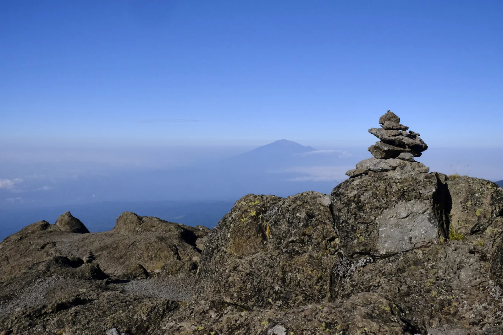 Stone cairn on a ridge with Mount Meru in the distance