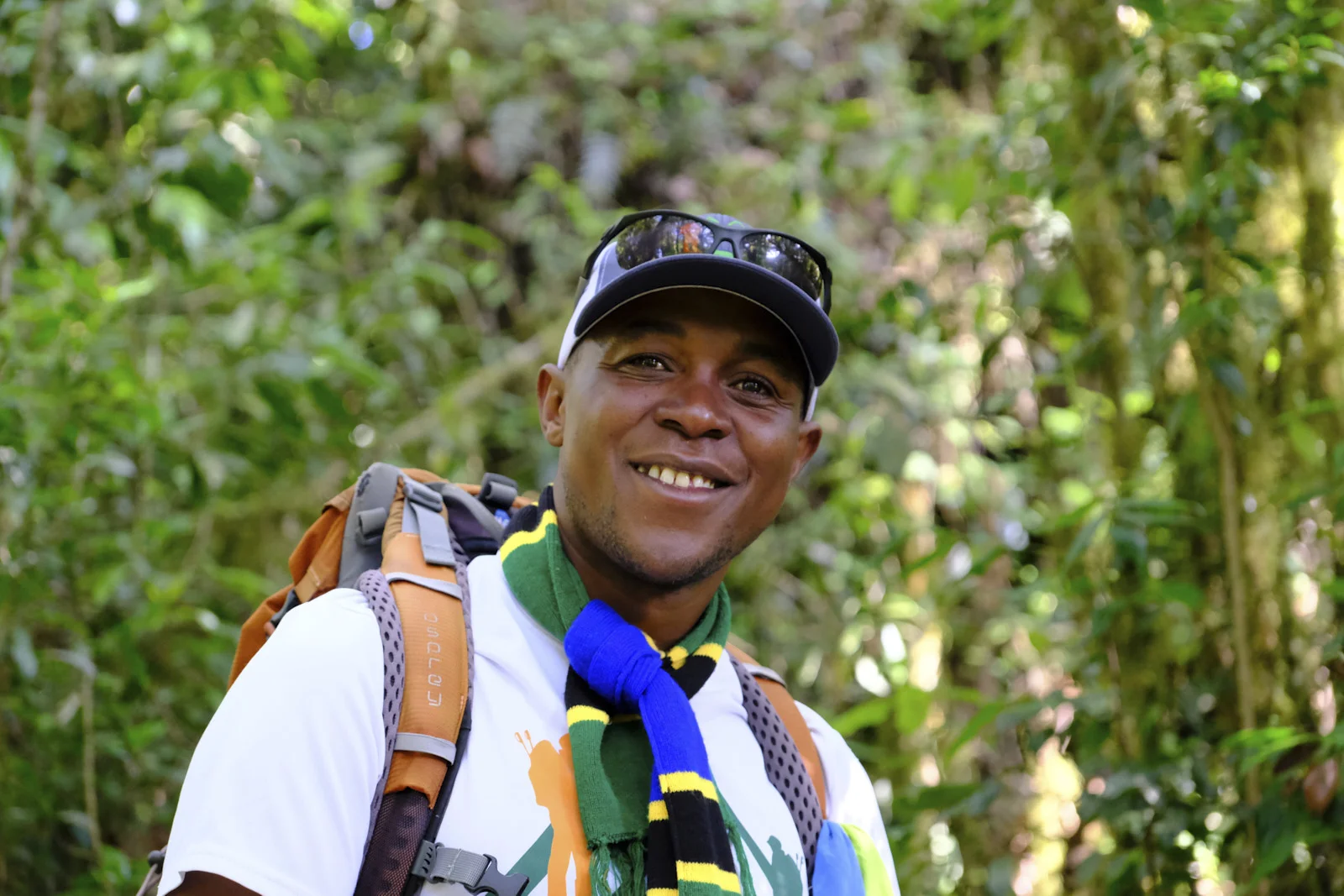 Smiling guide with a Tanzanian-colored scarf in the rainforest