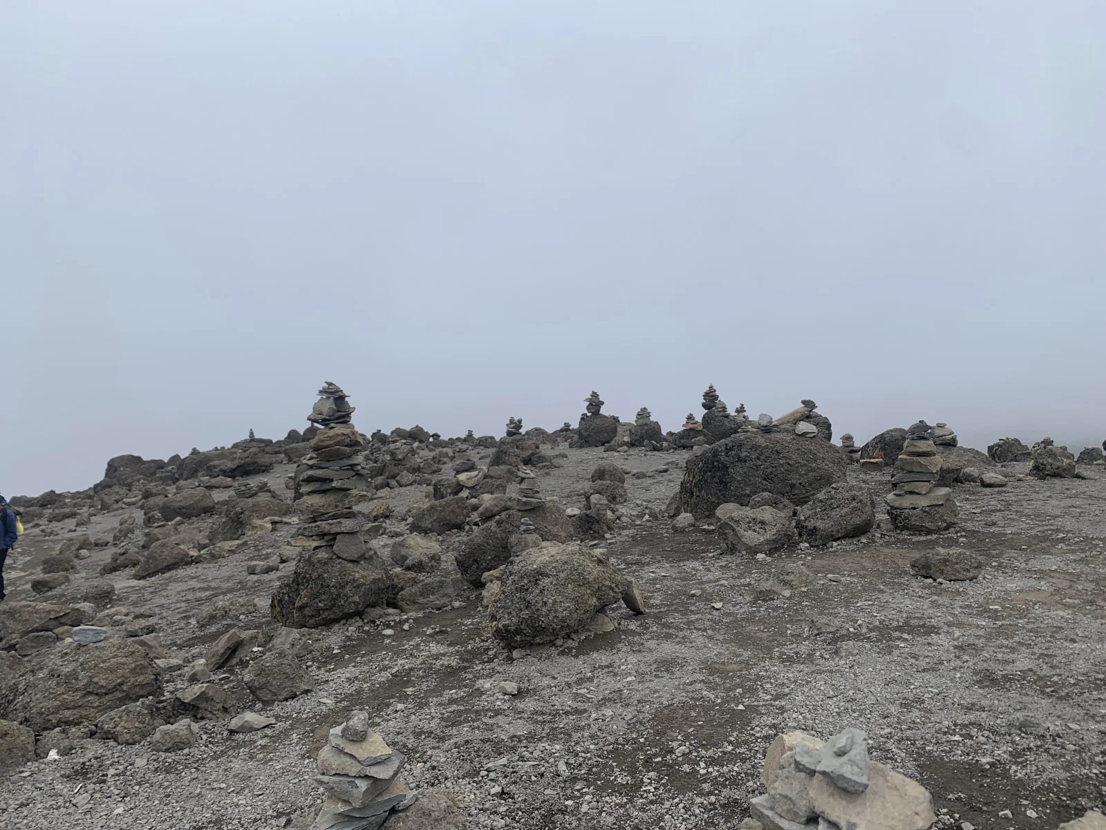Field of stone cairns in mist on the alpine desert