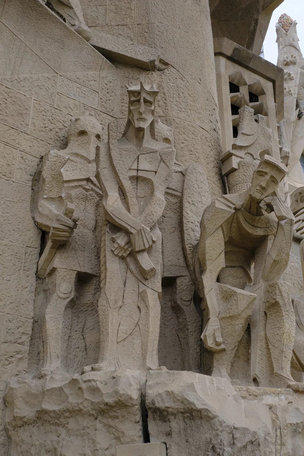 The Ecce Homo sculptures, including Christ with the crown of thorns, beside the Tiberius column on the Passion facade of the Sagrada Família in Barcelona.