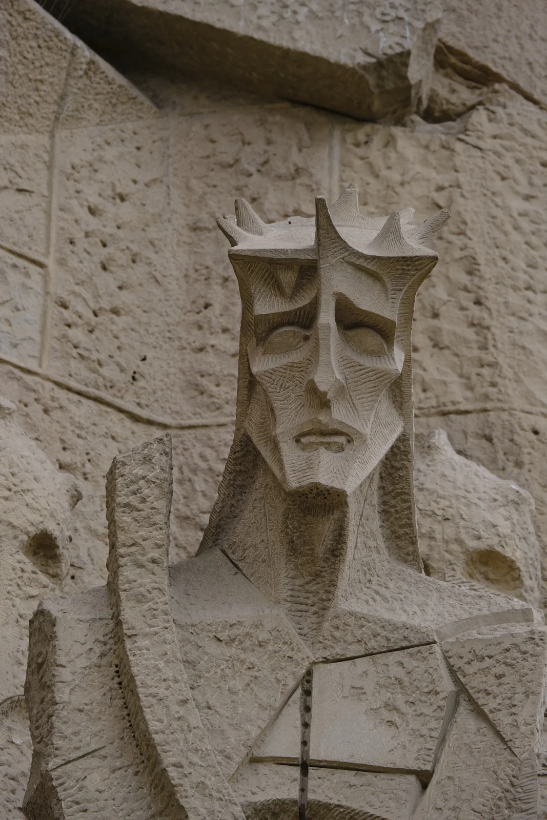 Stone head of Christ wearing the crown of thorns on the Passion facade of the Sagrada Família in Barcelona.