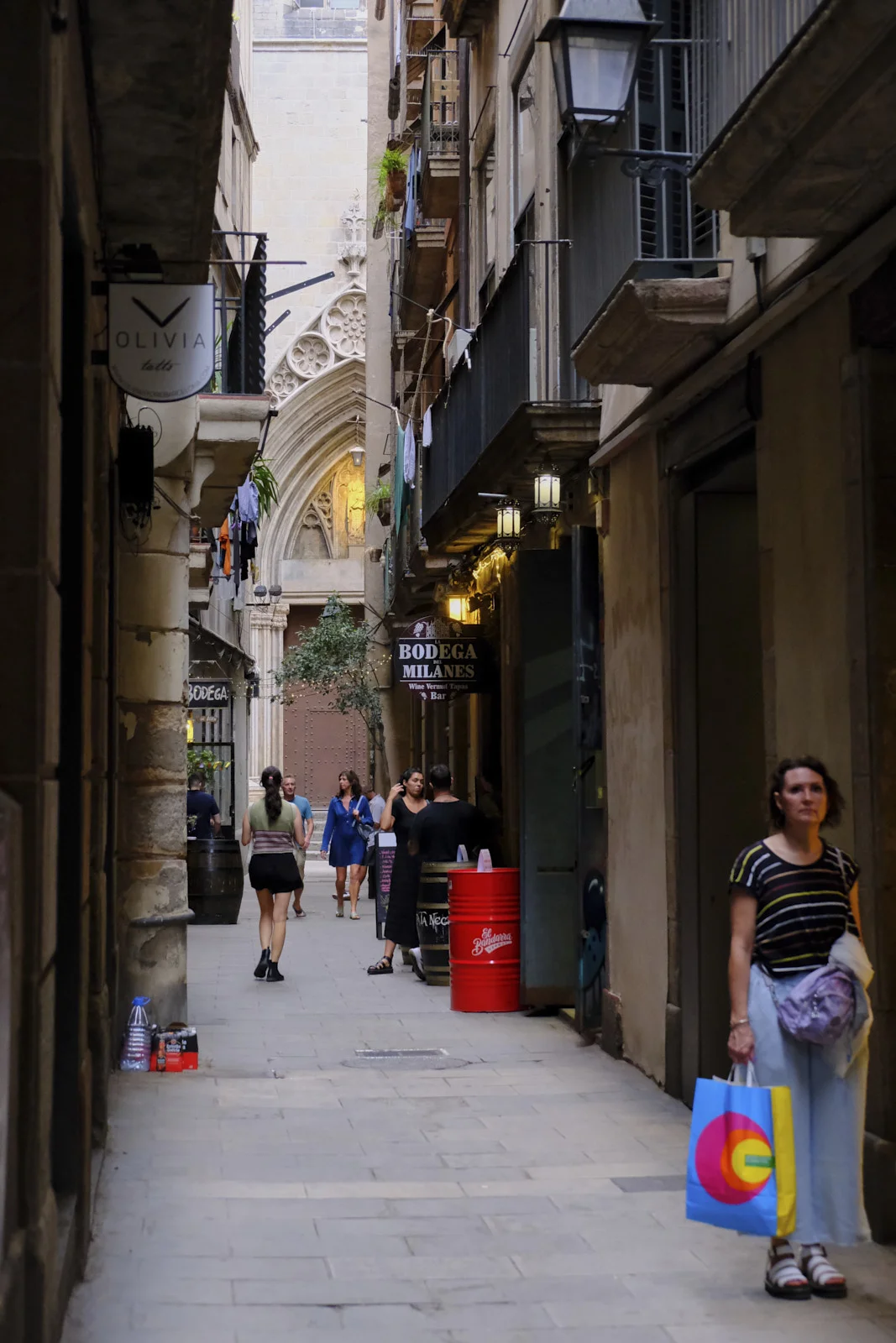 A lane in El Born, Barcelona, with the Bodega Milanes sign and a Gothic doorway at the far end.
