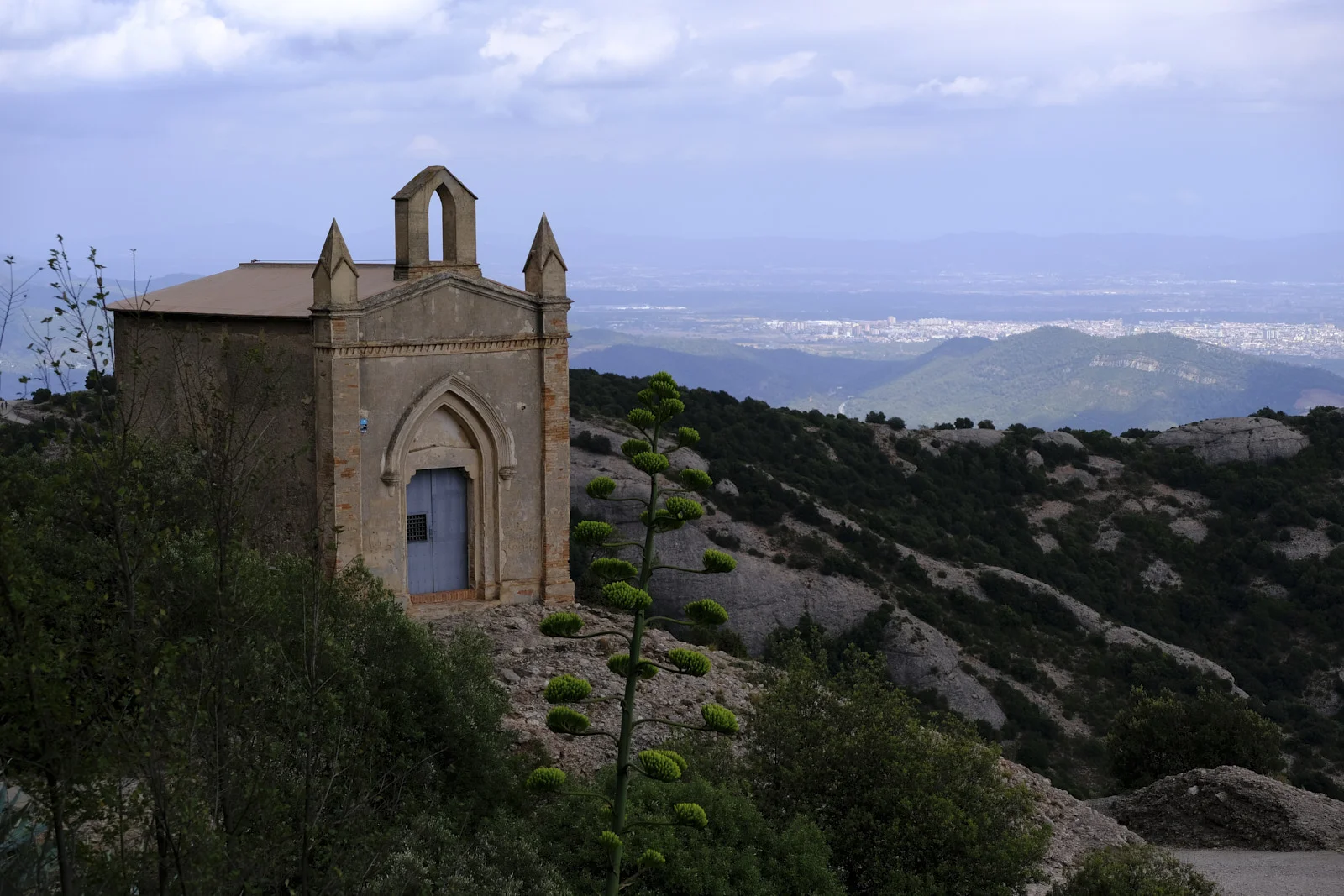 The chapel of Sant Joan at Montserrat, with a pointed doorway, corner pinnacles, and an empty bell gable.