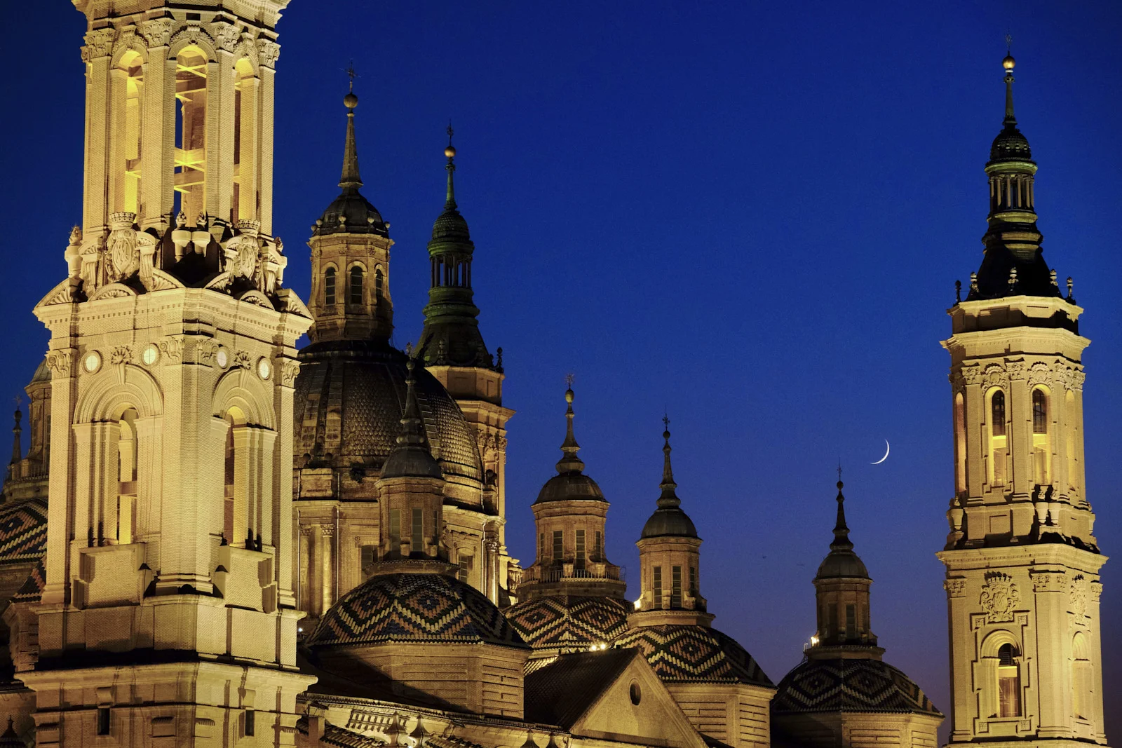 Two towers and the domes of the Basilica of Our Lady of the Pillar in Zaragoza fill the frame.